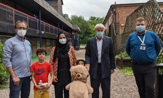 Andrew with Jamie Hitchins, Afghan refugees and a Royal Sutton Coldfield teddy bear for the family’s youngest child