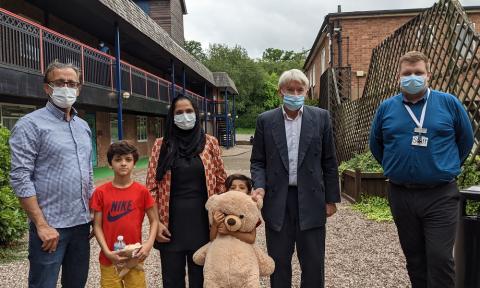 Andrew with Jamie Hitchins, Afghan refugees and a Royal Sutton Coldfield teddy bear for the family’s youngest child